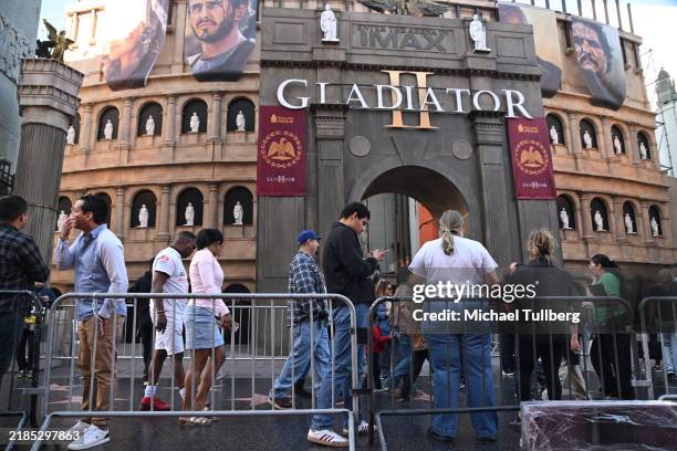 Tourists take pictures of the 40-foot tall by 80-foot wide Roman Colosseum themed facade built in celebration of the film "Gladiator II" at TCL...