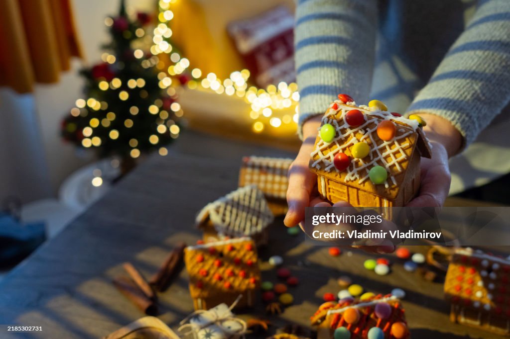 A woman is holding a DIY Gingerbread house