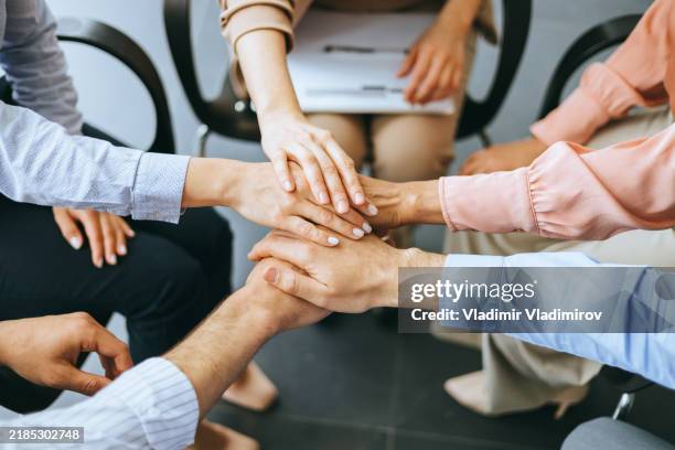 professionals in teamwork exercise placing hands together - hands clasped stock pictures, royalty-free photos & images