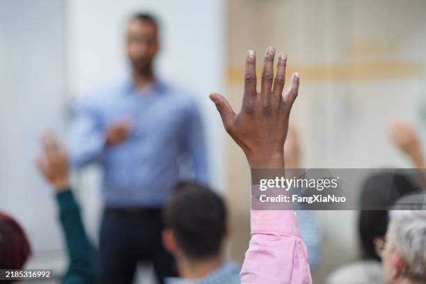 homme d’origine ethnique noire main levée en classe conférence séminaire de formation dans la salle de classe de l’école d’éducation posant une question à l’enseignant - lever la main photos et images de collection