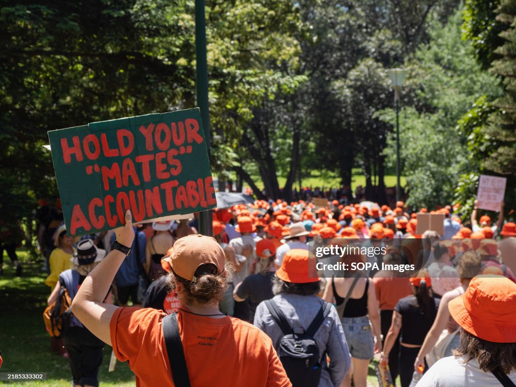 An attendee holds a sign expressing opinion in the crowd of...