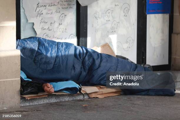 Homeless person sleeps in a sleeping bag in a street of Paris, France on November 20, 2024. Homeless individuals in the French capital are facing...