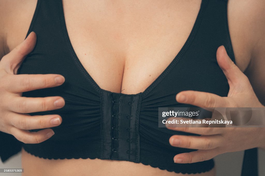 Woman applying on a bandage after mammoplasty