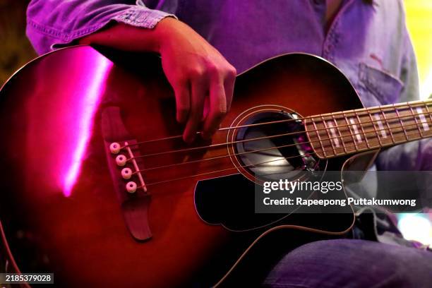 man playing an acoustic guitar on stage - musical instrument string stock pictures, royalty-free photos & images
