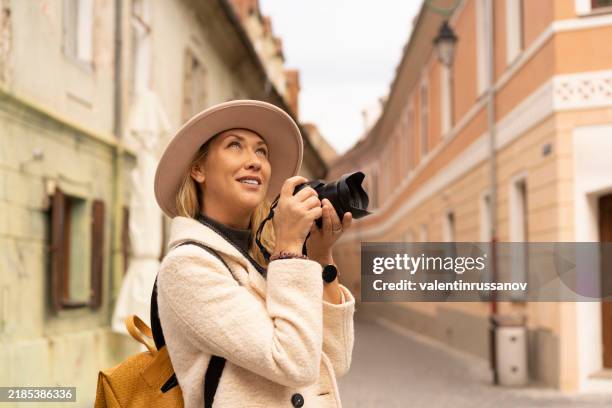 traveler enthusiastically snaps city moments, exploring unique scenes with her camera insight. - transylvania stock pictures, royalty-free photos & images