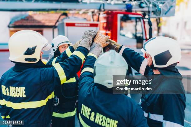 bomberos haciendo cinco altos - abrazo de grupo imágenes fotografías e imágenes de stock