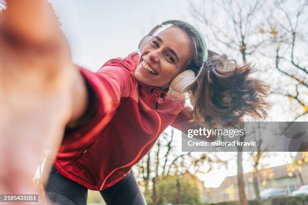 una mujer hermosa y alegre de 29 años haciendo ejercicio en el parque en un soleado y frío día de otoño. - entrenamiento deportivo fotografías e imágenes de stock