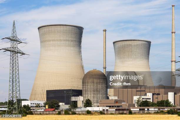nuclear power plant with two large cooling towers and electricity pylons (gundremmingen/ bavaria, germany) - atomkraftwerk stock-fotos und bilder