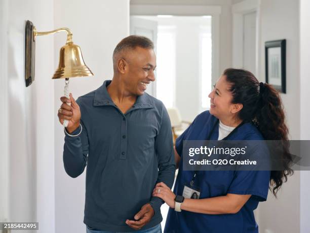 paciente adulto de quimioterapia terminando el tratamiento con un toque de campana ceremonial - campana fotografías e imágenes de stock