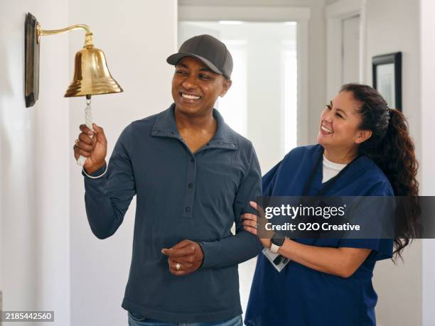 paciente adulto de quimioterapia terminando el tratamiento con un toque de campana ceremonial - campana fotografías e imágenes de stock