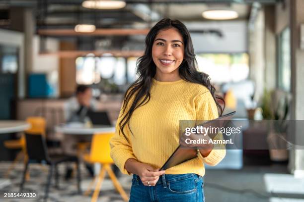selbstbewusste hispanische geschäftsfrau im coworking space - klemmbrett stock-fotos und bilder