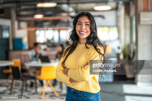 confident hispanic woman in modern office space - ung vuxen bildbanksfoton och bilder
