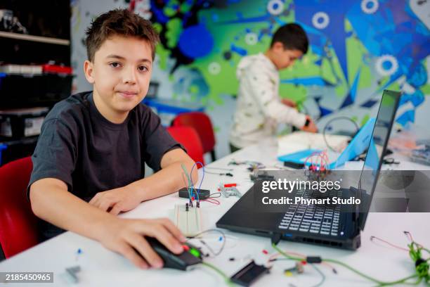 a male student participating in a hands-on robotics and stem education activity. - preteen models | young nonude teen models imagens e fotografias de stock