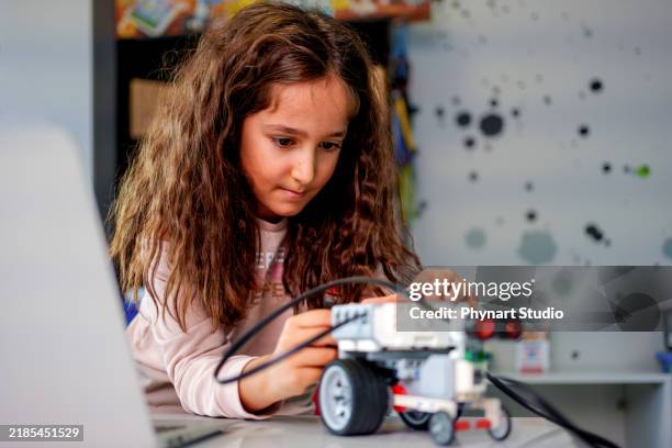 a female student participating in a hands-on robotics and stem education activity - preteen models | young nonude teen models imagens e fotografias de stock