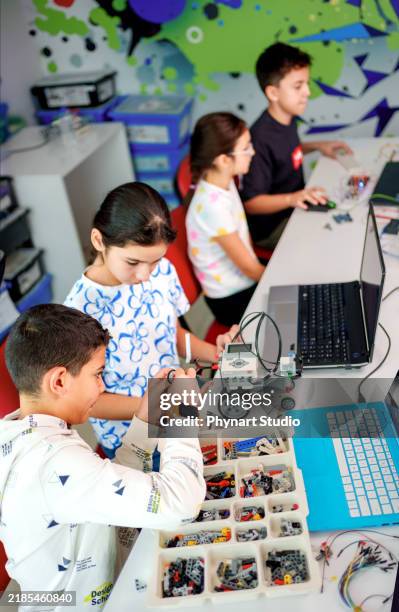 children engaged in robotics and stem education workshop - stereotype stock pictures, royalty-free photos & images