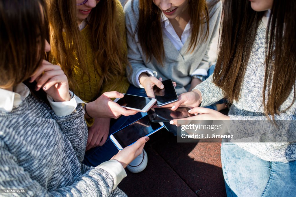 Four Young Women Using Smartphones On The Street High-Res Stock Photo ...