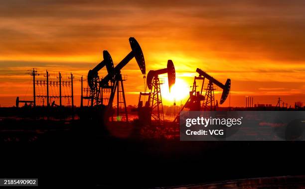 Oil pumpjacks operate at Daqing Oilfield at sunset on November 18, 2024 in Daqing, Heilongjiang Province of China.