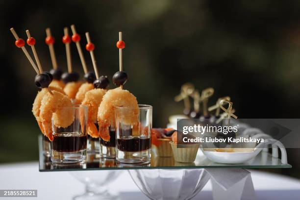 a table with a variety of appetizers and drinks, including shrimp, olives - antipasto stock pictures, royalty-free photos & images