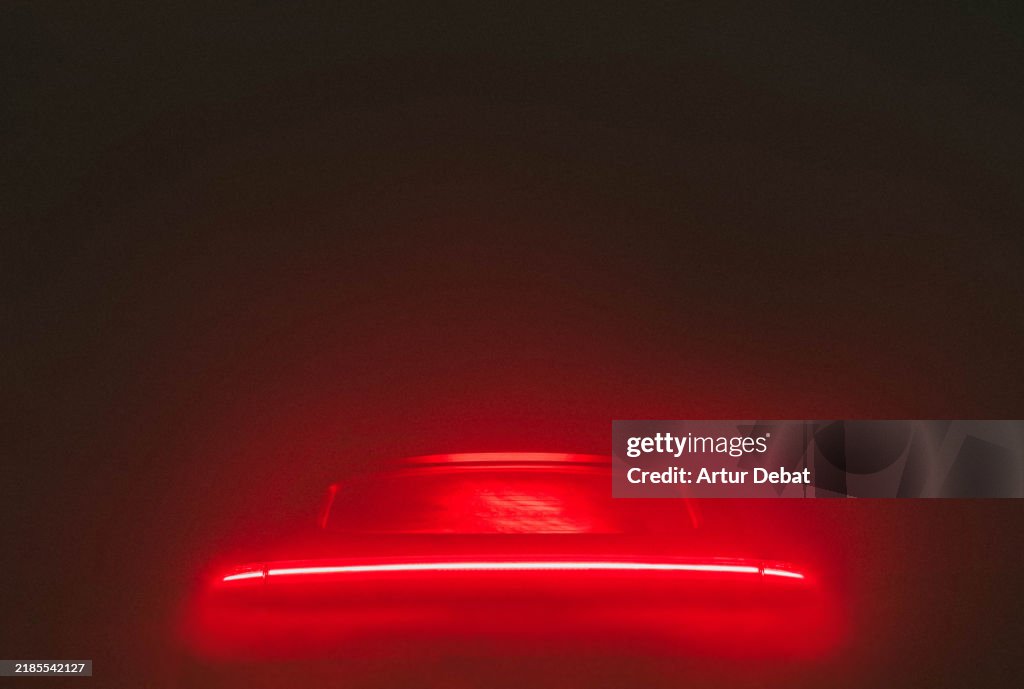 Automotive minimalism design with red tail light against black background