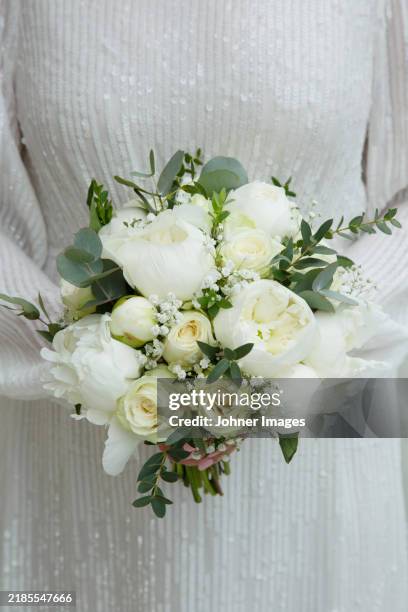 midsection of bride holding bouquet of flowers - bride stock pictures, royalty-free photos & images