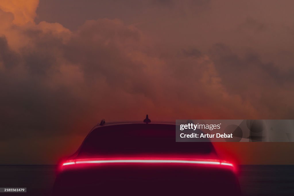 Automotive futuristic design car with LED tail light against the dusk sky