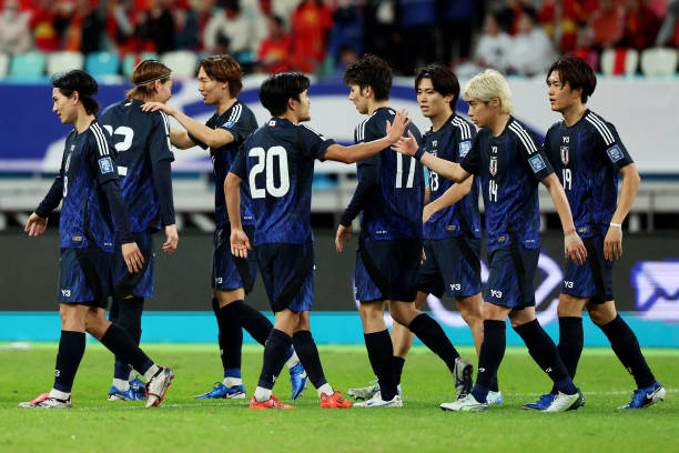 Koki Ogawa of Japan celebrates with teammates after scoring the team's third goal against China in the second half during the FIFA World Cup Asian...