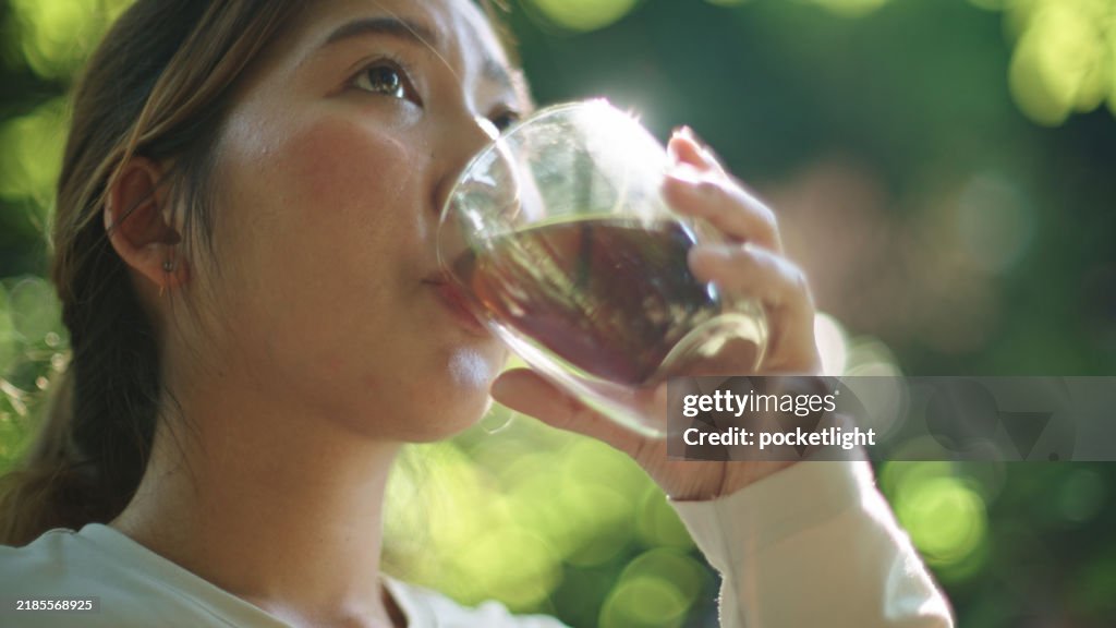 Woman sipping coffee or tea.