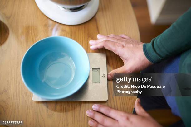 man preparing scale to measure ingredients for a cake - broken scale stock pictures, royalty-free photos & images