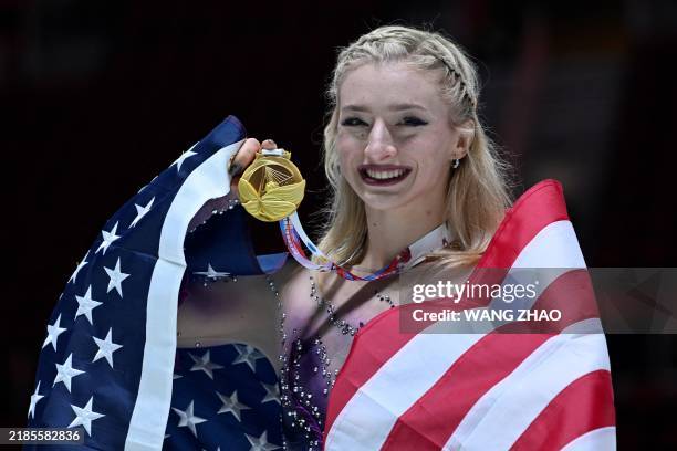Gold medallist US' Amber Glenn poses with her national flag during the medal ceremony for women's free skating event in the ISU figure skating Grand...
