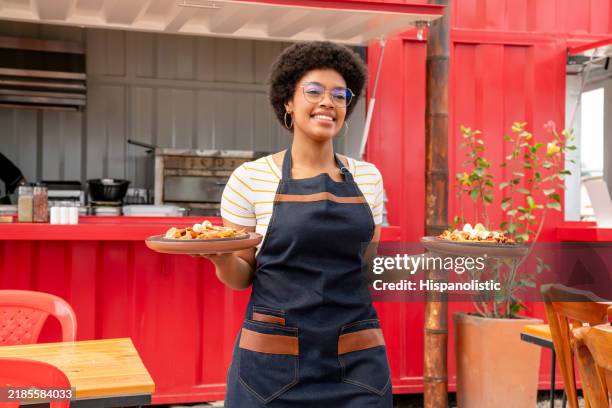 serveuse heureuse servant une cuisine dans un restaurant - garçon de café photos et images de collection
