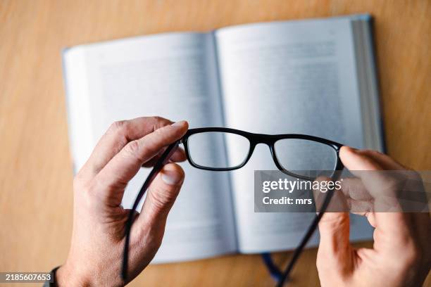 hands holding eyeglasses - reading glasses stock pictures, royalty-free photos & images