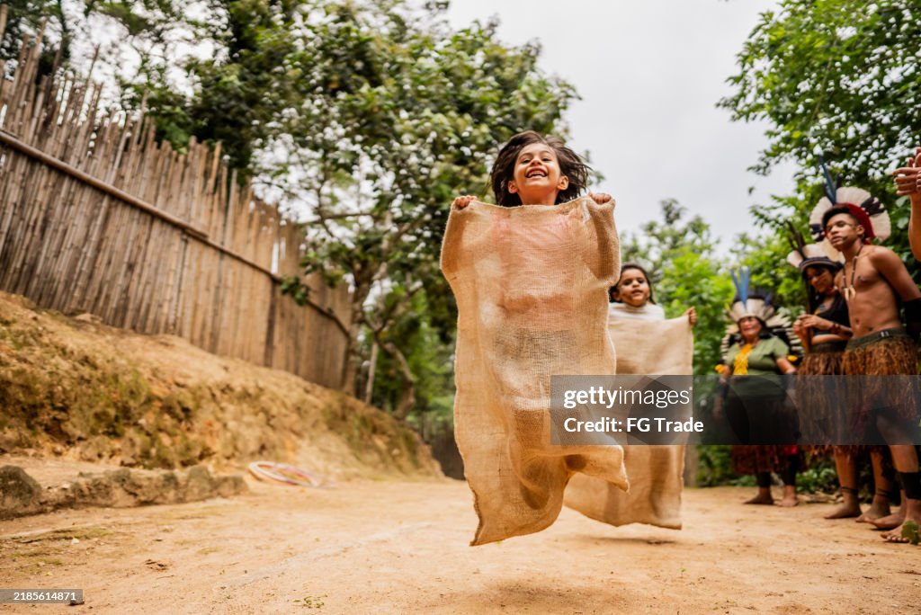 Children having fun with a sack race during a field trip to an indigenous village
