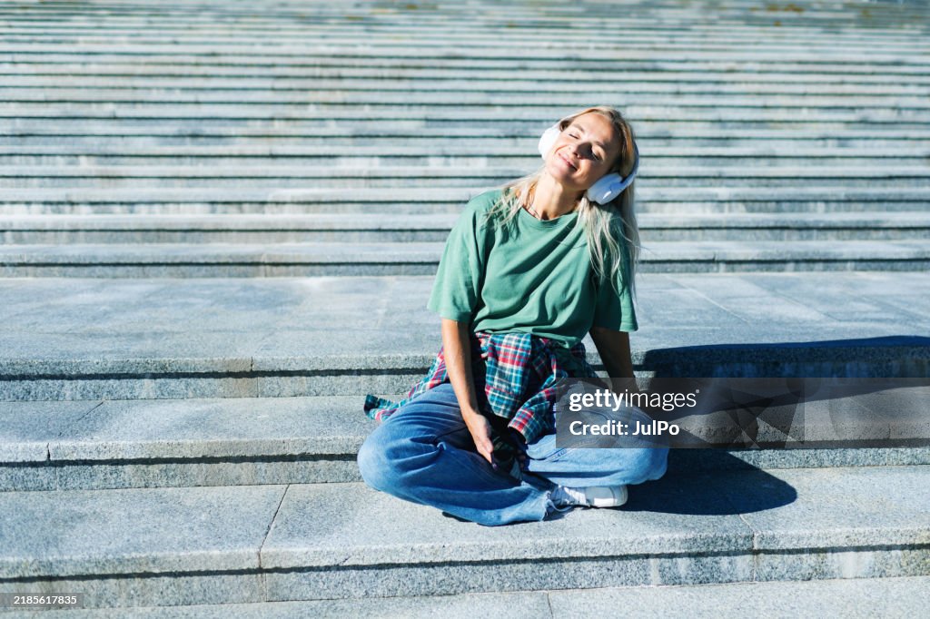 Mid adult woman listening to music