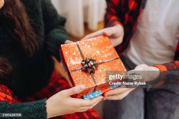 the christmas present in the couple's hands, close-up view - espírito natalino imagens e fotografias de stock