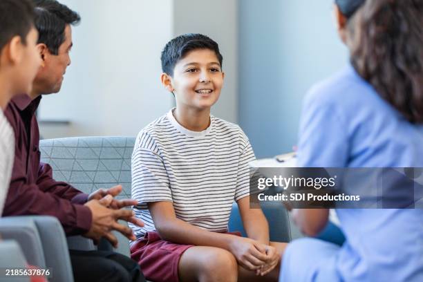 pediatric nurse talks with male patient - pediatric nurse stock pictures, royalty-free photos & images