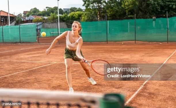 mujer joven jugando al tenis - deporte de raqueta fotografías e imágenes de stock