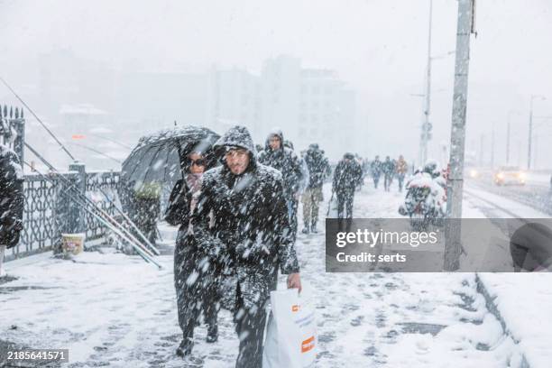 escena nevada en el puente de gálata, estambul, turquía, con peatones y tráfico - nevar fotografías e imágenes de stock
