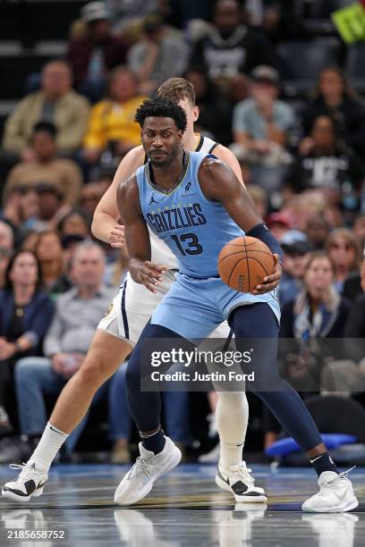 Jaren Jackson Jr. #13 of the Memphis Grizzlies handles the ball against Julian Strawther of the Denver Nuggets during the first half of the Emirates...