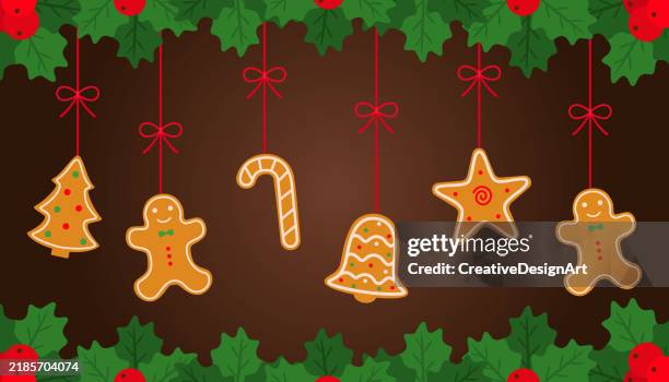 ilustraciones, imágenes clip art, dibujos animados e iconos de stock de colgando galletas de jengibre navideñas y bayas de acebo sobre fondo marrón. galletas en forma de árbol de navidad, bastón de caramelo, estrella, campana y hombre de jengibre - galletas de navidad