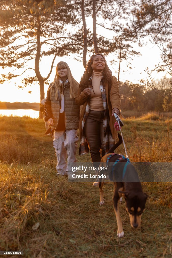 A beautiful black woman and her step-daughter enjoying life walking dogs whilst grounding in nature