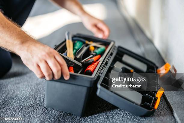 électricien ouvrant une boîte à outils dans un appartement vide en rénovation - boîte à outils photos et images de collection