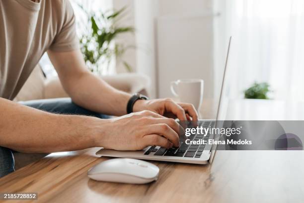 close-up of male hands on laptop keyboard. male freelancer working from home. home office - computer mouse pad hand stock pictures, royalty-free photos & images