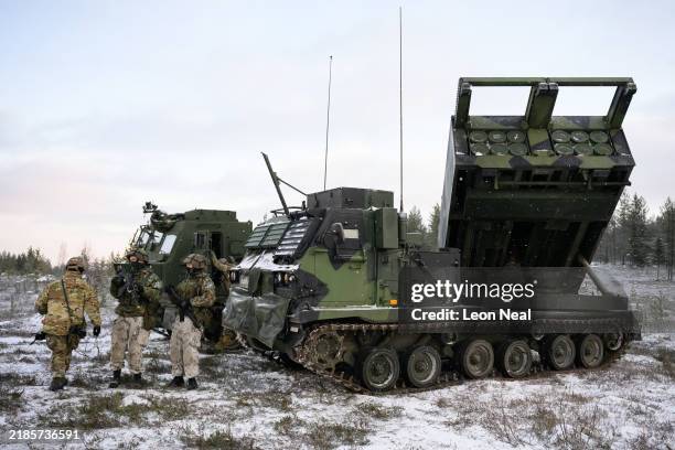 Soldiers stand with an MLRS M270 A2 mobile rocket system during the NATO "Exercise Lightning Strike" on November 20, 2024 near Heinu, Finland. The...