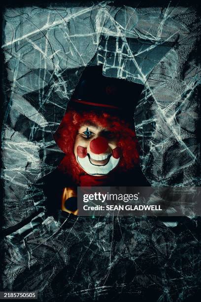 spooky clown behind smashed glass - picture of a jester stock pictures, royalty-free photos & images