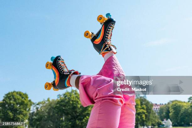 low section of woman wearing rainbow striped roller skates under blue sky - svensk sommar bildbanksfoton och bilder
