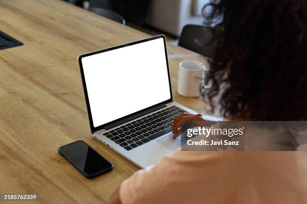 latin american woman working from home on laptop with white screen - blank screen stock pictures, royalty-free photos & images