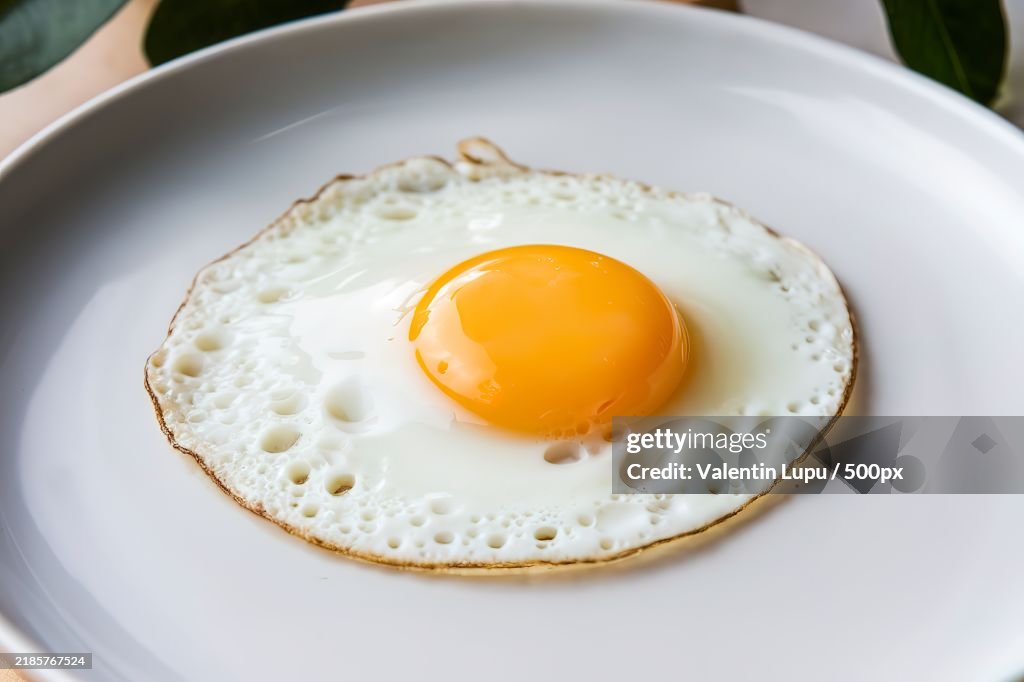 A photo of a sunny-side-up egg on a white plate