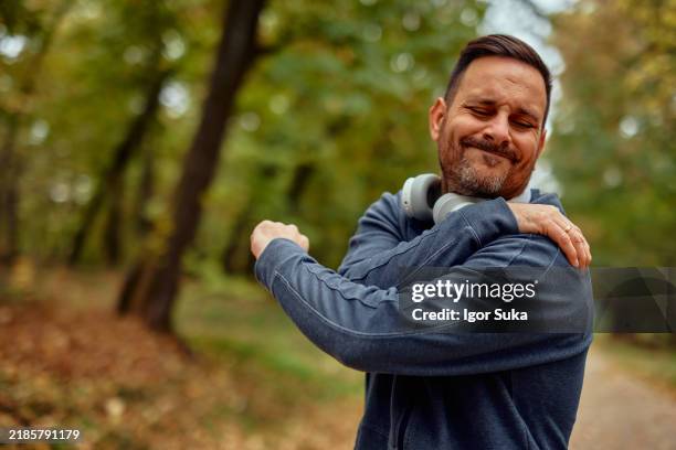 handsome young sportsman have physical injury of shoulder during a practice - shoulder stock pictures, royalty-free photos & images