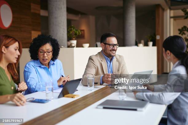 vielfältiges team bei einem geschäftstreffen im modernen büro - verschiedene berufe stock-fotos und bilder