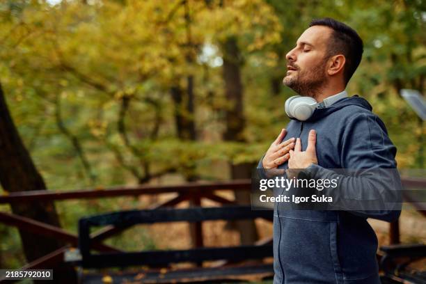 porträt eines mannes im mittleren erwachsenenalter, der frische luft atmet - einatmen stock-fotos und bilder